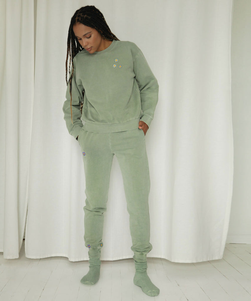 Sage green high waisted joggers decorated with flower patches